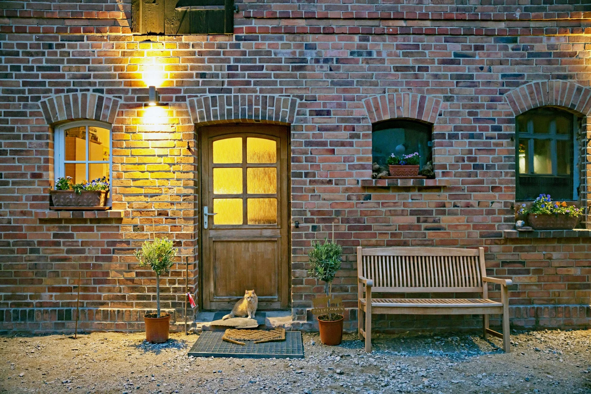 Das alte Backsteinhaus des Milchschafhofs am Abend mit beleuchteten Fenstern