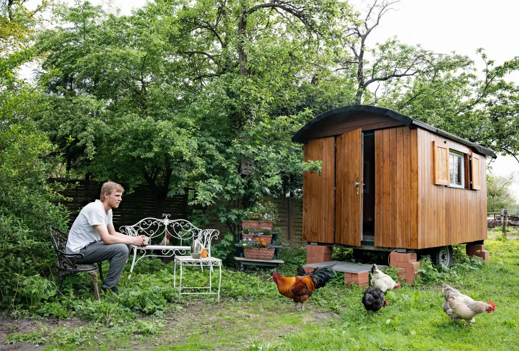 Schäferwagen im Obstgarten mit Sitzplatz davor